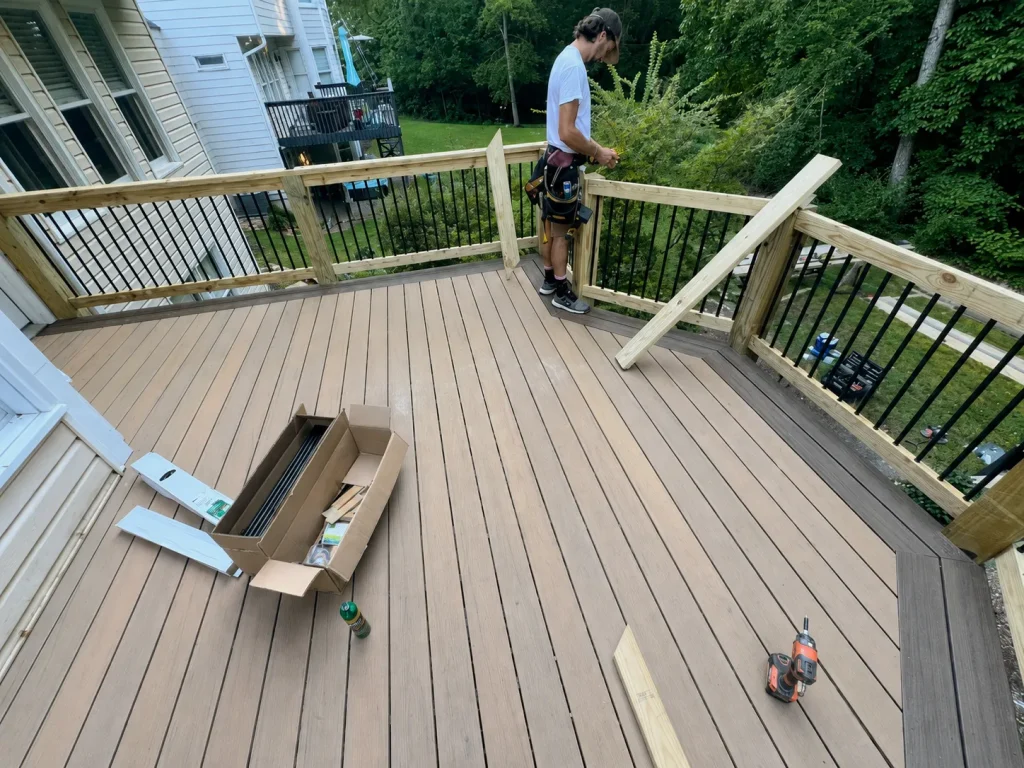 Contractor finishing railings on a two-tone composite deck in Indianapolis, IN