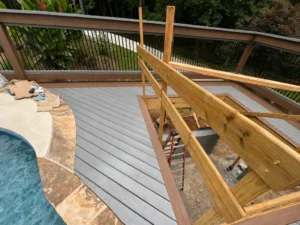 Gray composite pool deck under construction with brown border boards in Indianapolis