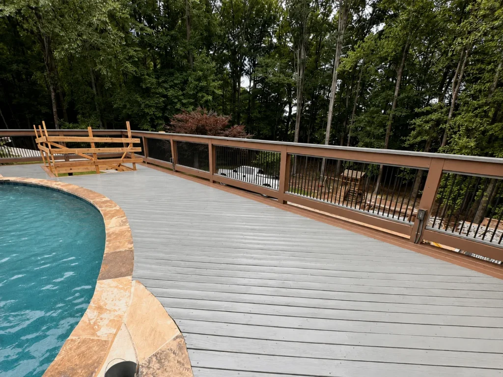 Completed gray composite pool deck with brown border and black railings in Indianapolis