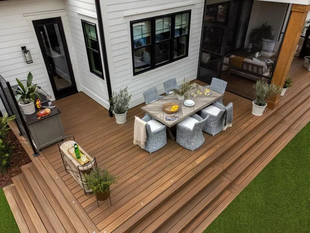 Multi-level brown composite deck with dining area and wide wraparound steps in Indianapolis