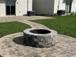 Circular stone fire pit connected to a paver walkway at an Indianapolis home