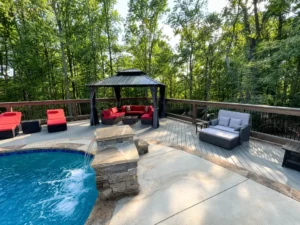 Gray composite pool deck with a covered gazebo and outdoor seating in Indianapolis