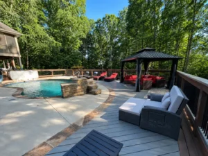 Custom poolside composite deck with gazebo, lounge seating, and black railings in Indianapolis
