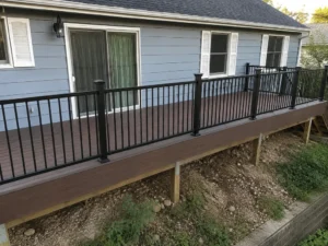 Narrow elevated brown composite deck with black metal railings in Indianapolis