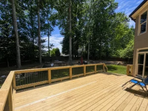 Large pressure-treated wood deck overlooking a wooded Indianapolis backyard